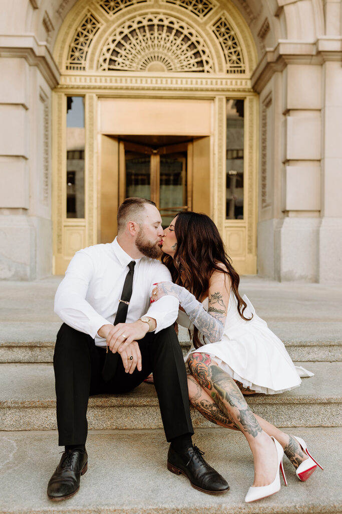 bride and groom kiss on the steps of the douglas county courthouse after their intimate ceremony
